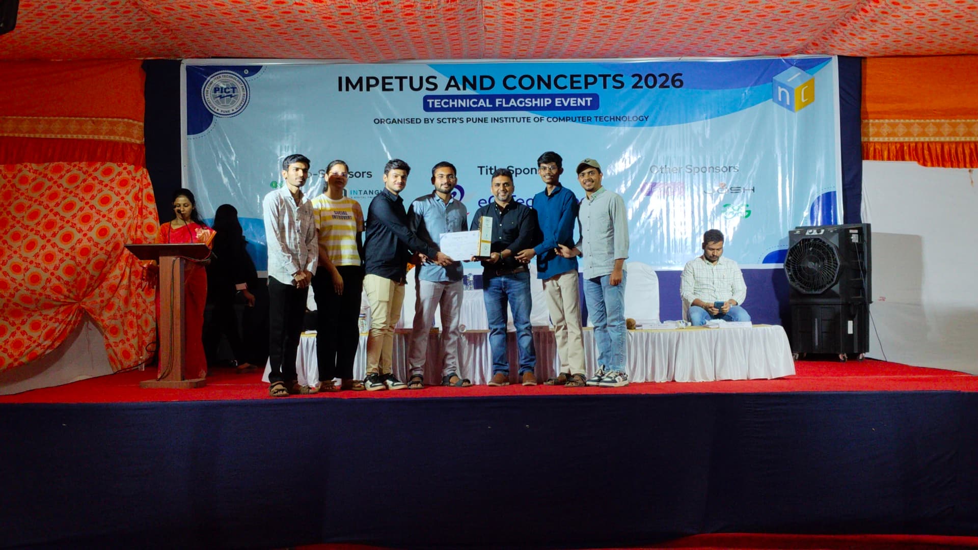 Rohit Mane receiving the winners' award on stage at Impetus & Concepts 2026, PICT Pune.